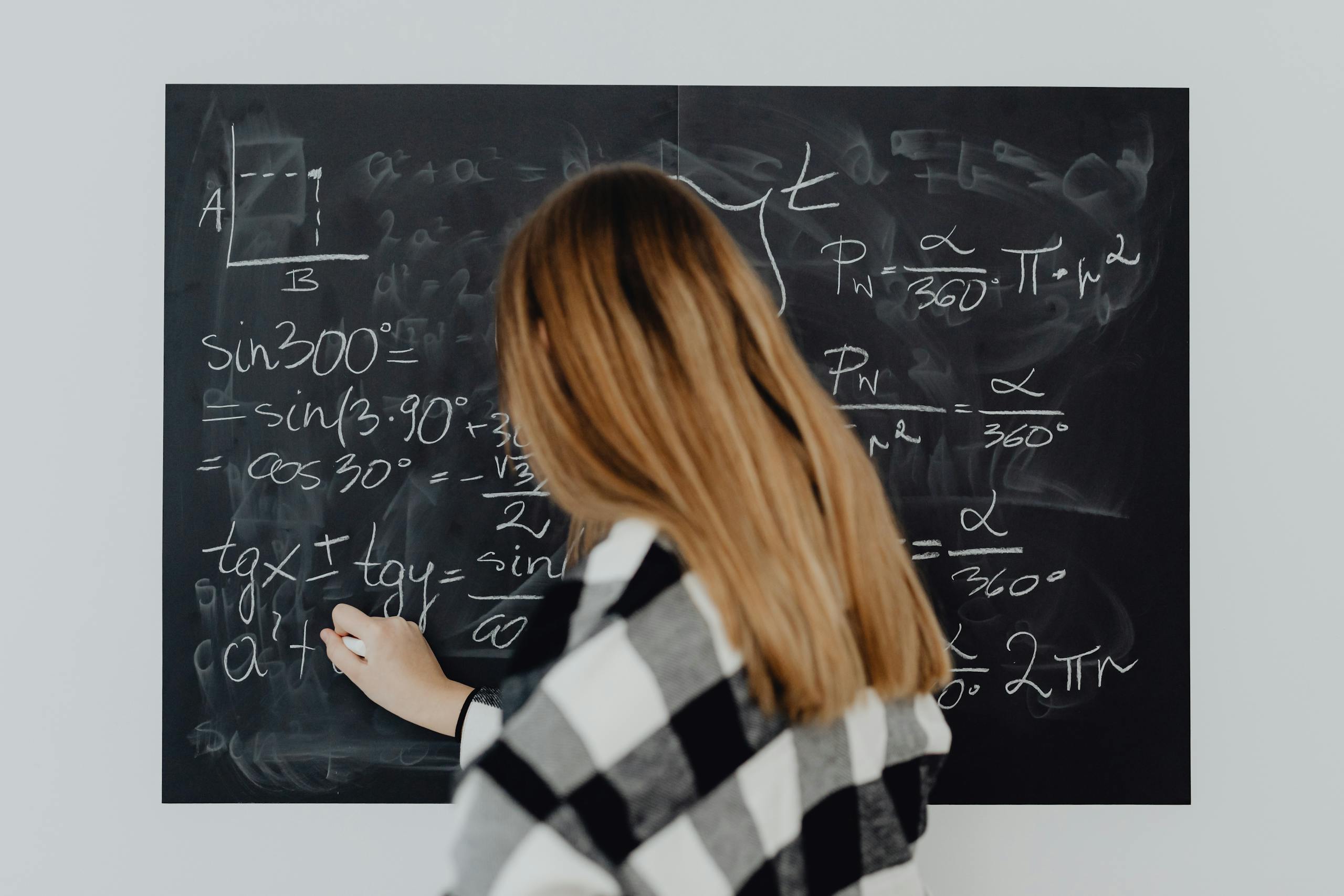 Woman Writing Trigonometry Calculations on Blackboard